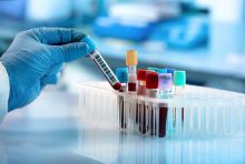 gloved hand holding lab tube